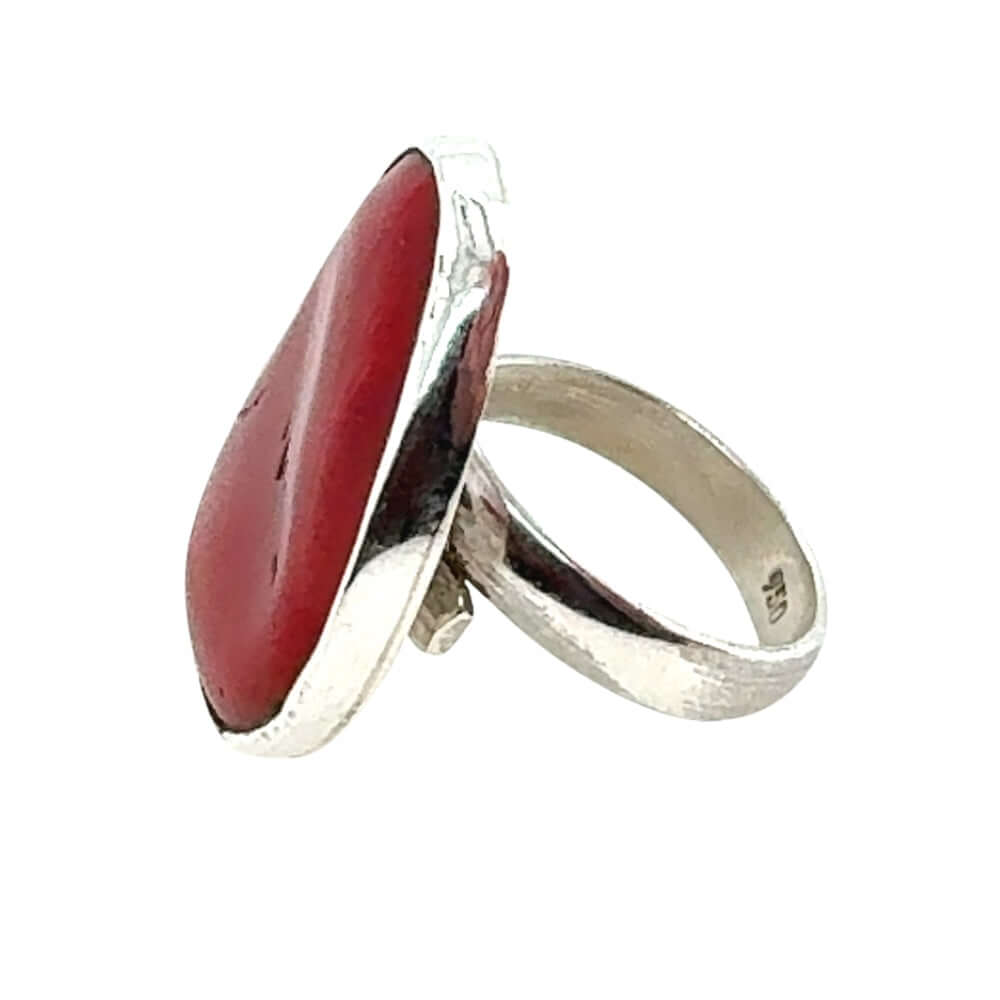 Silver ring with a red coral on a white background
