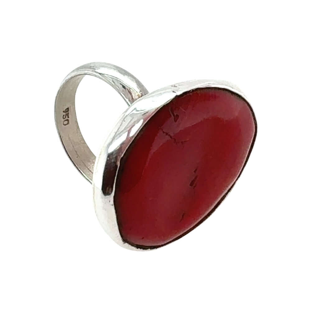 Silver ring with a large red coral on a white background