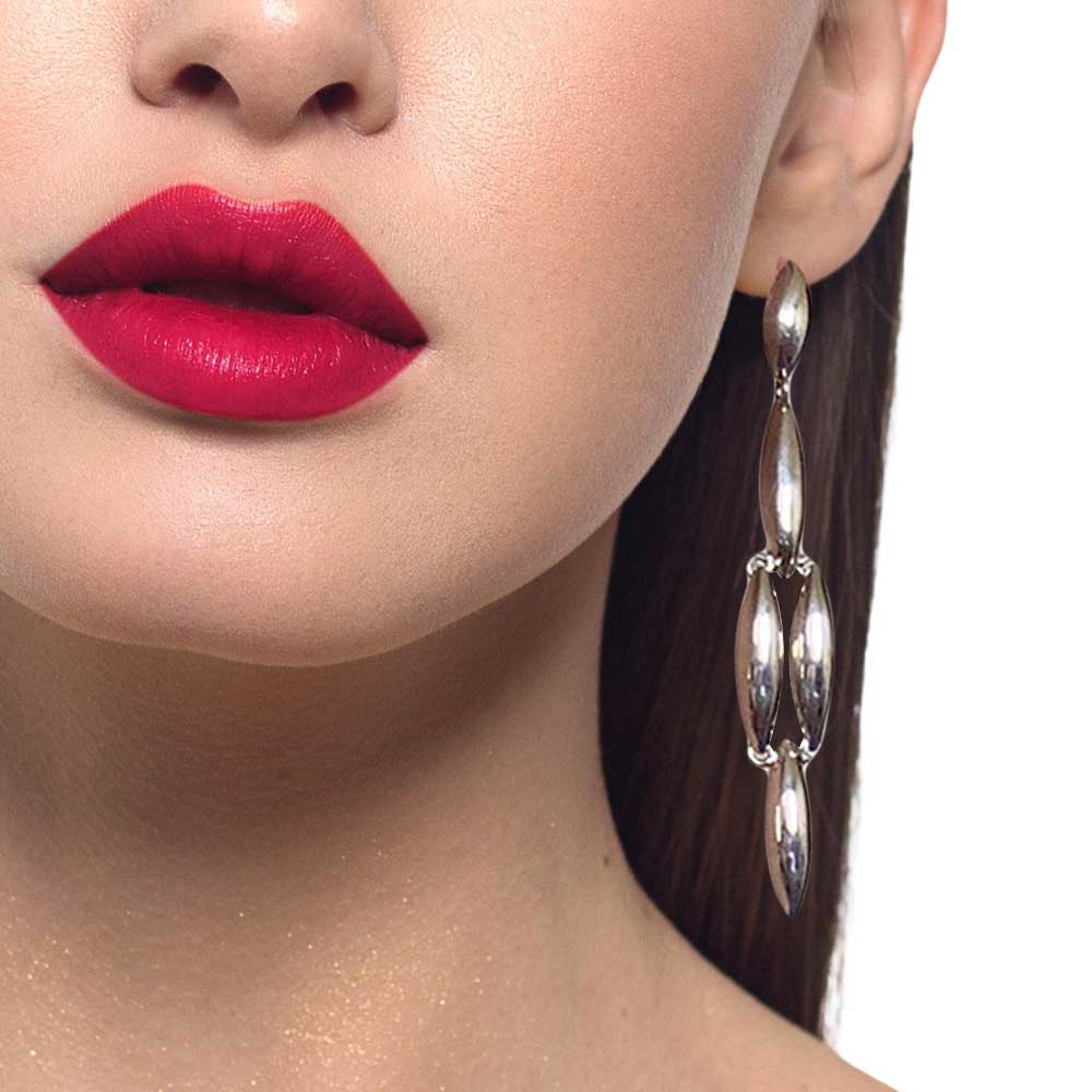 Close-up of a woman's face with red lipstick and silver earrings on a white background