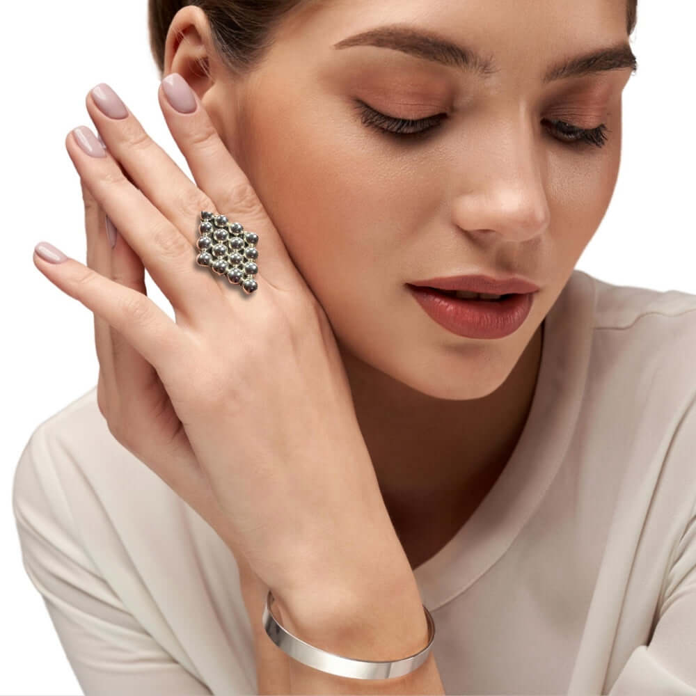 Woman wearing a silver ring with a geometric form on a neutral background