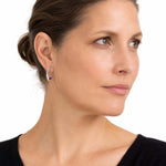 Elegant silver arc earrings with amethyst shown on a model to illustrate their scale and daily wear appeal.