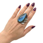High-purity silver chunky ring with gemstones shown on a hand to illustrate its elongated scale and adjustable size 7 fit.