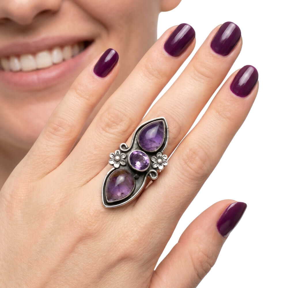 High-purity silver chunky ring showing the central faceted amethyst and outer cabochons on a hand to illustrate its scale and adjustable size 7 fit.