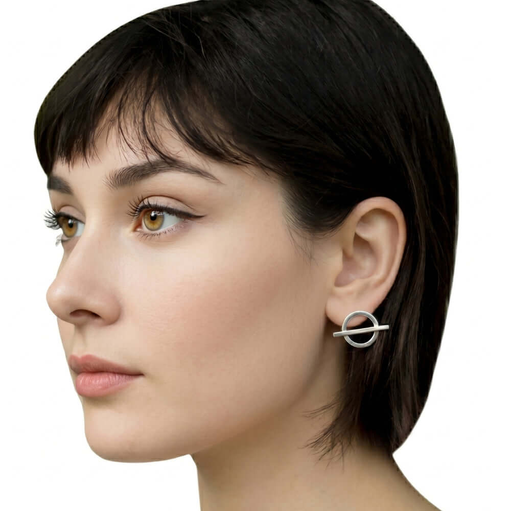 Profile view of a woman wearing minimalist geometric silver studs handcrafted by Stuart Alarcón