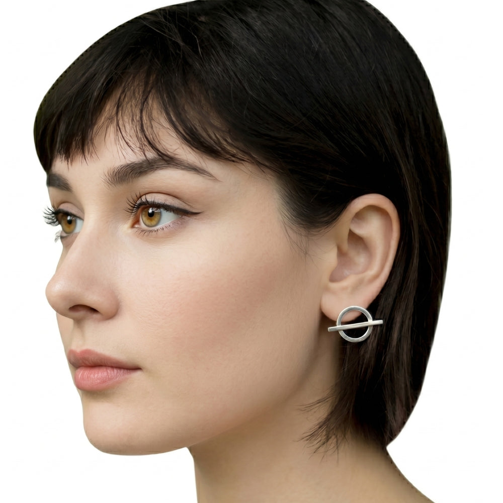 Profile view of a woman wearing minimalist geometric silver studs handcrafted by Stuart Alarcón