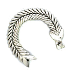 Unclasped sterling silver fishbone bracelet in an open curve.