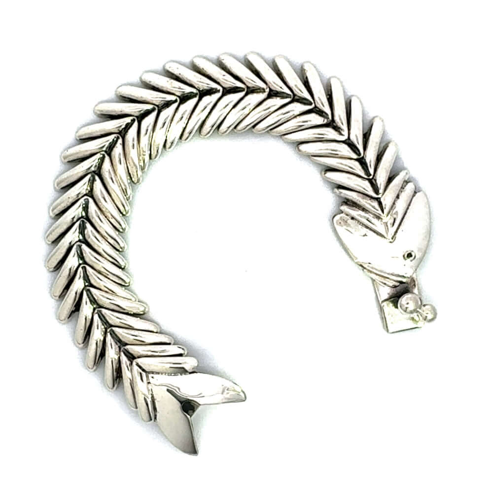 Unclasped sterling silver fishbone bracelet in an open curve.