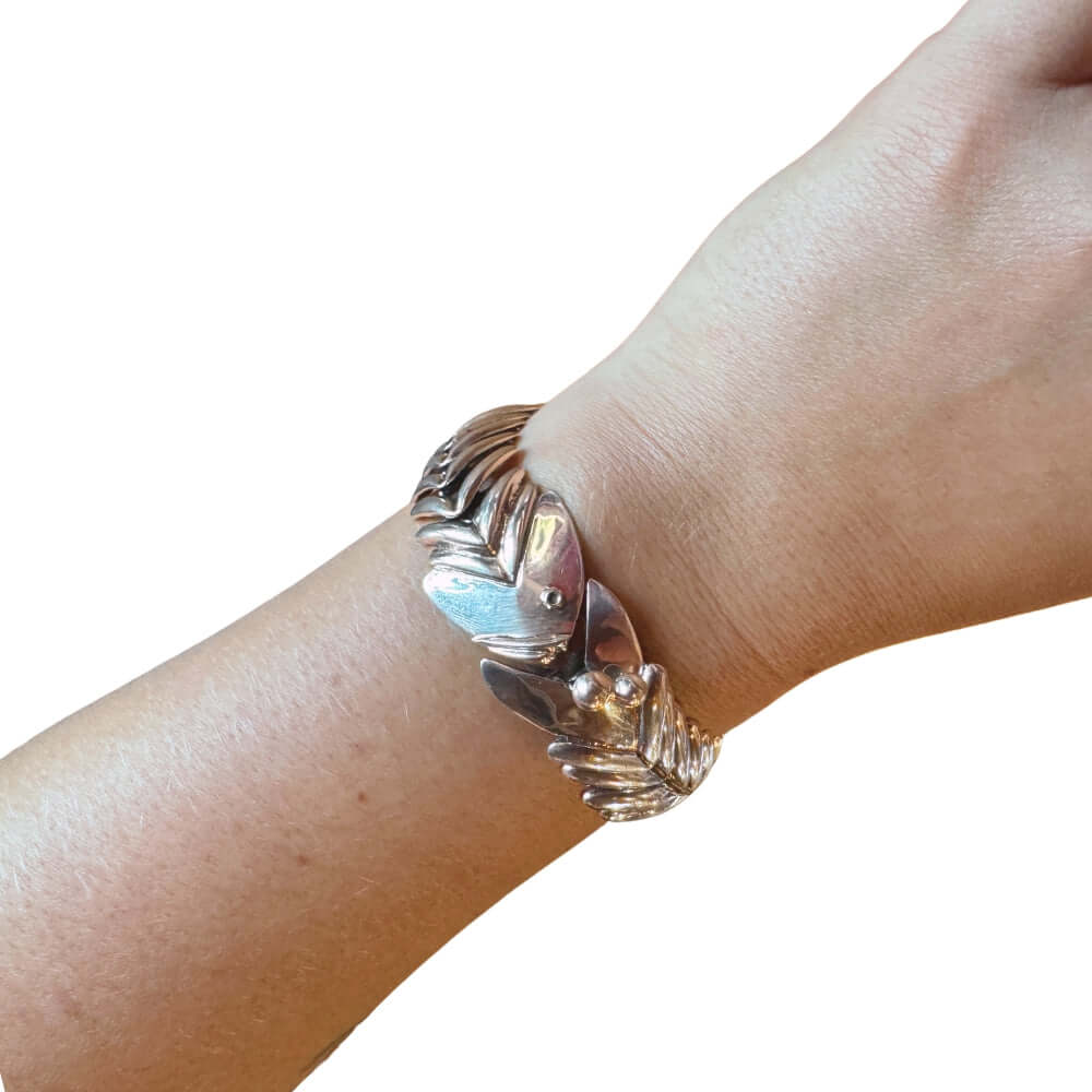 Sterling silver fishbone statement bracelet worn on a wrist.