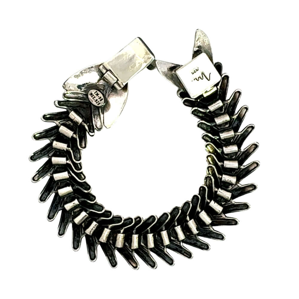 Underside of articulated silver fishbone bracelet showing inner links.