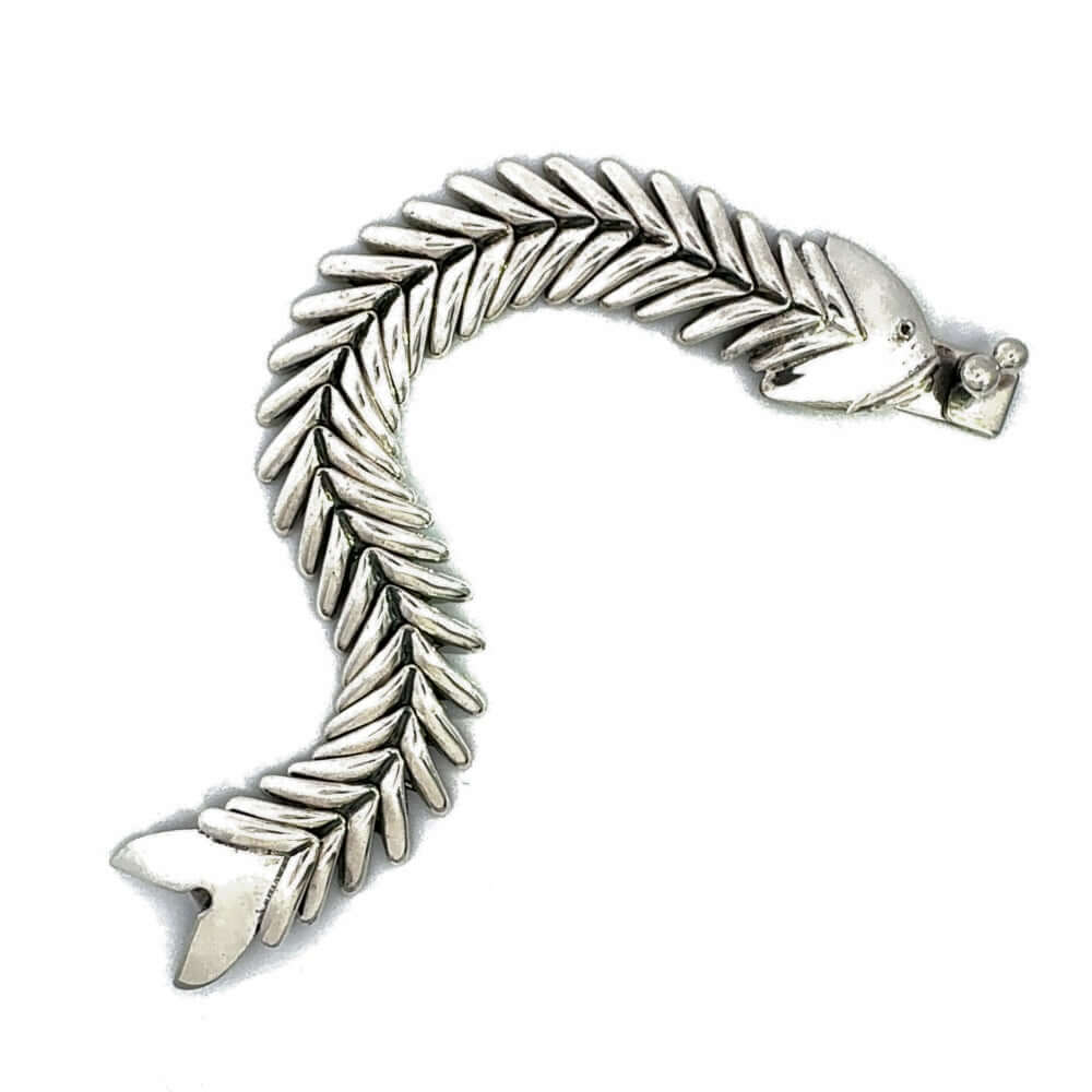 Articulated silver fishbone bracelet laid flat in an S-shape.