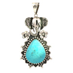 Handcrafted sterling silver elephant pendant featuring a teardrop turquoise stone framed by beaded filigree and floral accents.