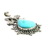 Low-angle side view highlighting the smooth cabochon finish of the teardrop turquoise stone and intricate oxidized silver scrollwork.