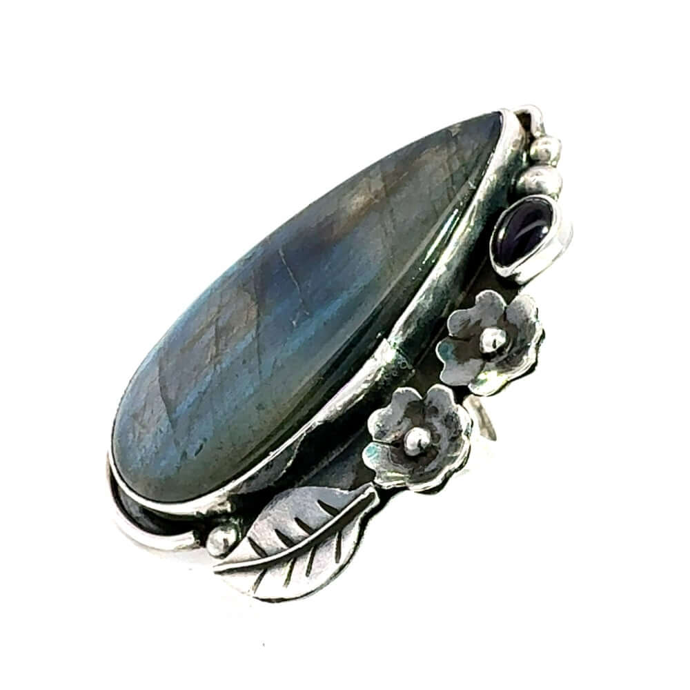 Side angle view showcasing the smooth bezel settings and detailed botanical carvings of the artisan long ring.