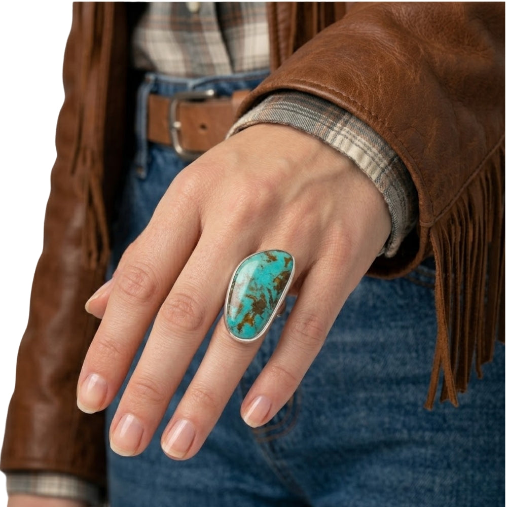 Close-up view of the artisan chunky turquoise ring worn on a hand, illustrating its bold scale and powerful presence against the skin.