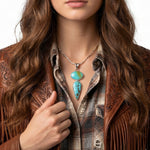 Close-up view of the artisan double turquoise pendant worn on a silver chain, illustrating its elegant linear drop and rich blue tones against the skin.