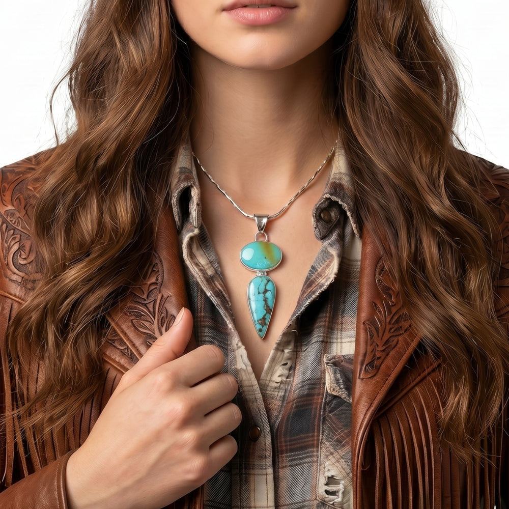Close-up view of the artisan double turquoise pendant worn on a silver chain, illustrating its elegant linear drop and rich blue tones against the skin.