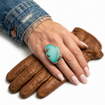 Close-up view of the artisan chunky irregular turquoise ring worn on a hand, illustrating its bold scale and powerful presence against the skin.