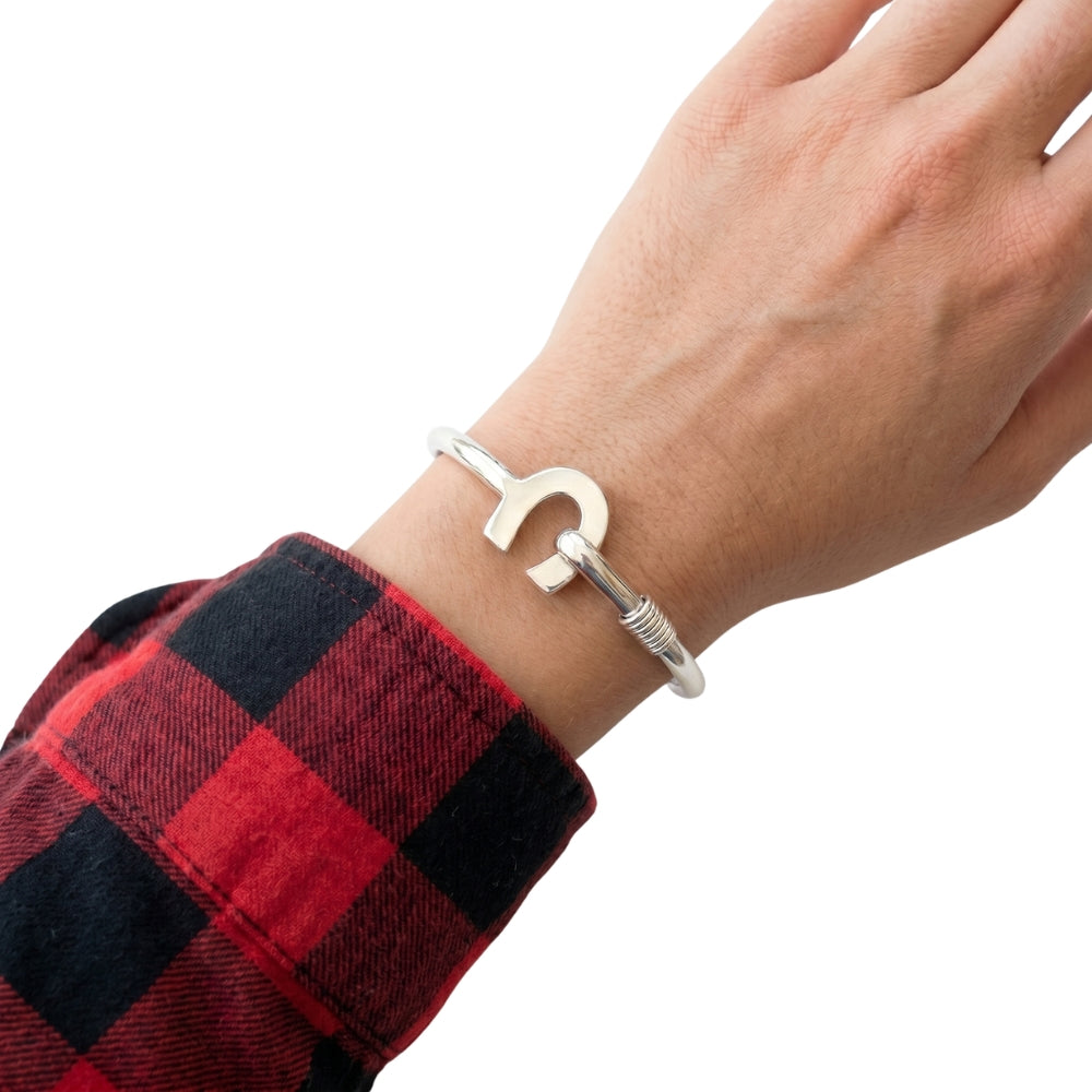 Close-up view of the artisan western silver bangle worn on a wrist, illustrating its high-polish finish and comfortable fit.