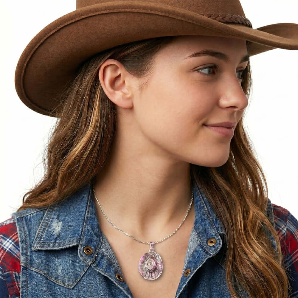 Close-up view of the artisan western silver textured cowgirl large hat pendant worn on a delicate chain.