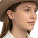 Close-up view of an artisan western silver textured hat earring worn on an ear, illustrating its delicate daily drop scale and high-contrast finish.
