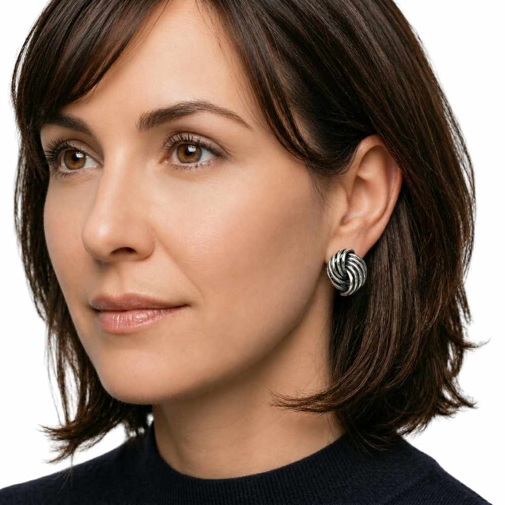 Close-up of a woman wearing a Taxco silver earring on a white background