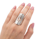 Close-up view of the artisan big spiral oval silver ring worn on a hand, illustrating its bold scale and powerful presence against the skin.