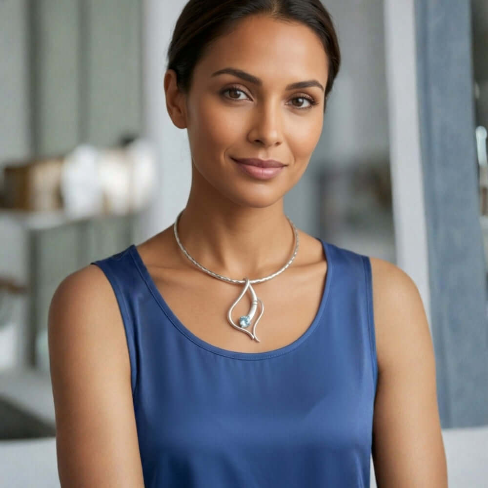 Woman wearing a handmade sterling silver and blue topaz pendant by Fernando Vergara