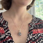 Woman wearing a sterling silver woven basket pendant necklace
