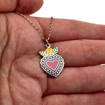 Small silver enamel Mexican heart charm with rose held in hand to show actual size