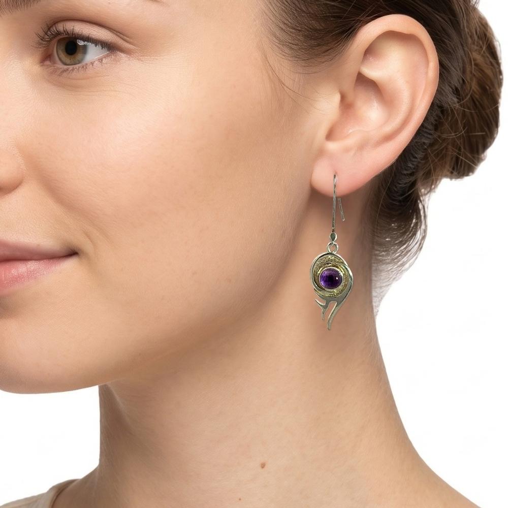 Model wearing handcrafted 925 silver flame earrings with purple amethyst stone on French wire hook.