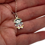 Small silver enamel Mexican Maria doll charm held in hand to show actual size