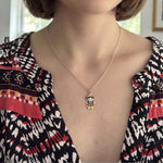 Woman wearing a sterling silver enamel Muñeca María pendant necklace