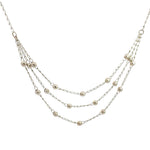 Close up of a delicate 24-inch three-strand sterling silver bead necklace