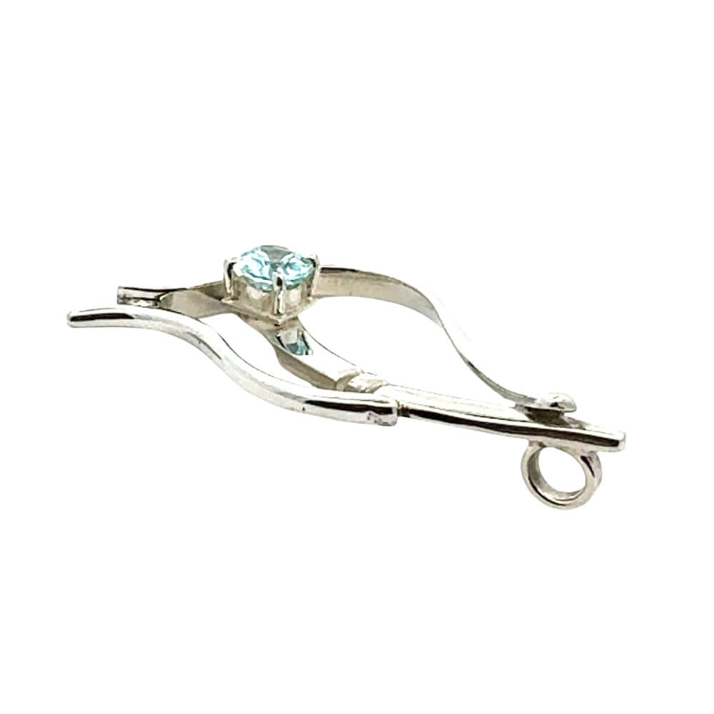Side profile of a handcrafted sterling silver and blue topaz necklace pendant