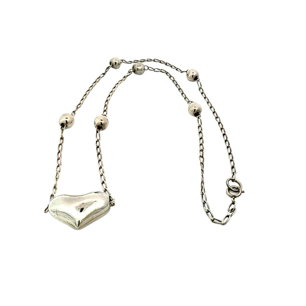 Silver necklace with a heart-shaped pendant on a white background