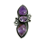 Front view of a handmade 950 silver long ring featuring a vertical cascade of three natural amethysts nestled in carved silver flowers.