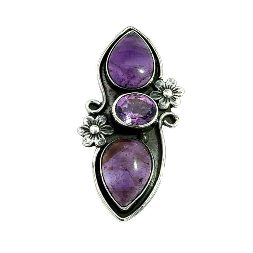 Front view of a handmade 950 silver long ring featuring a vertical cascade of three natural amethysts nestled in carved silver flowers.