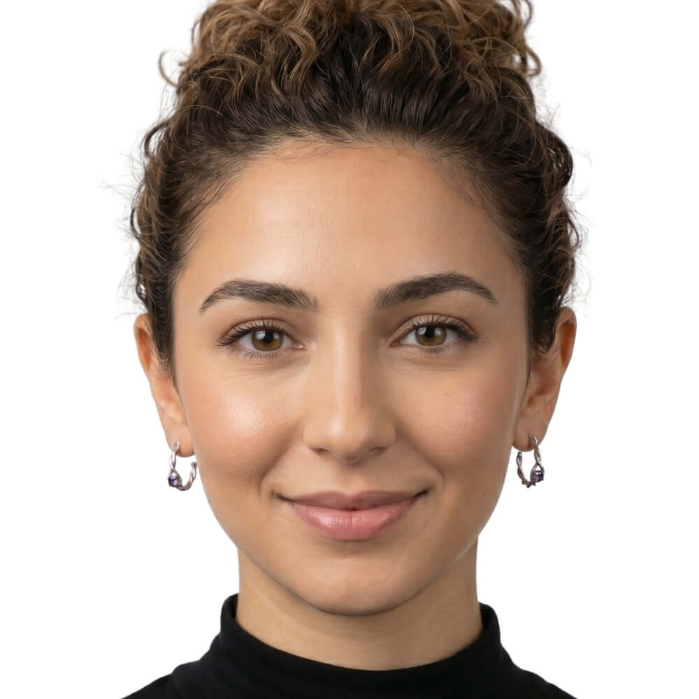 Woman wearing delicate Taxco silver hoops with amethyst to show the graceful scale and fit