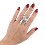 Hand wearing a silver ring with red nail polish on a white background