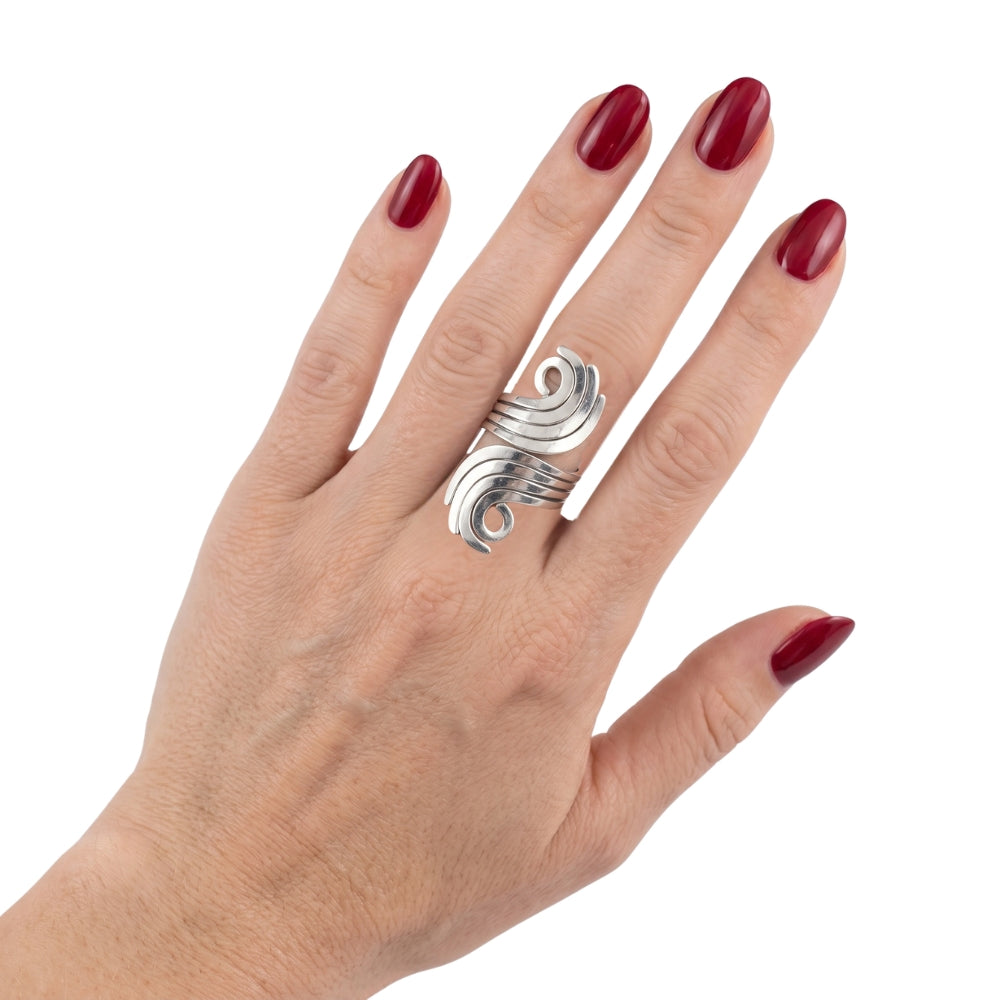 Hand wearing a silver ring with red nail polish on a white background