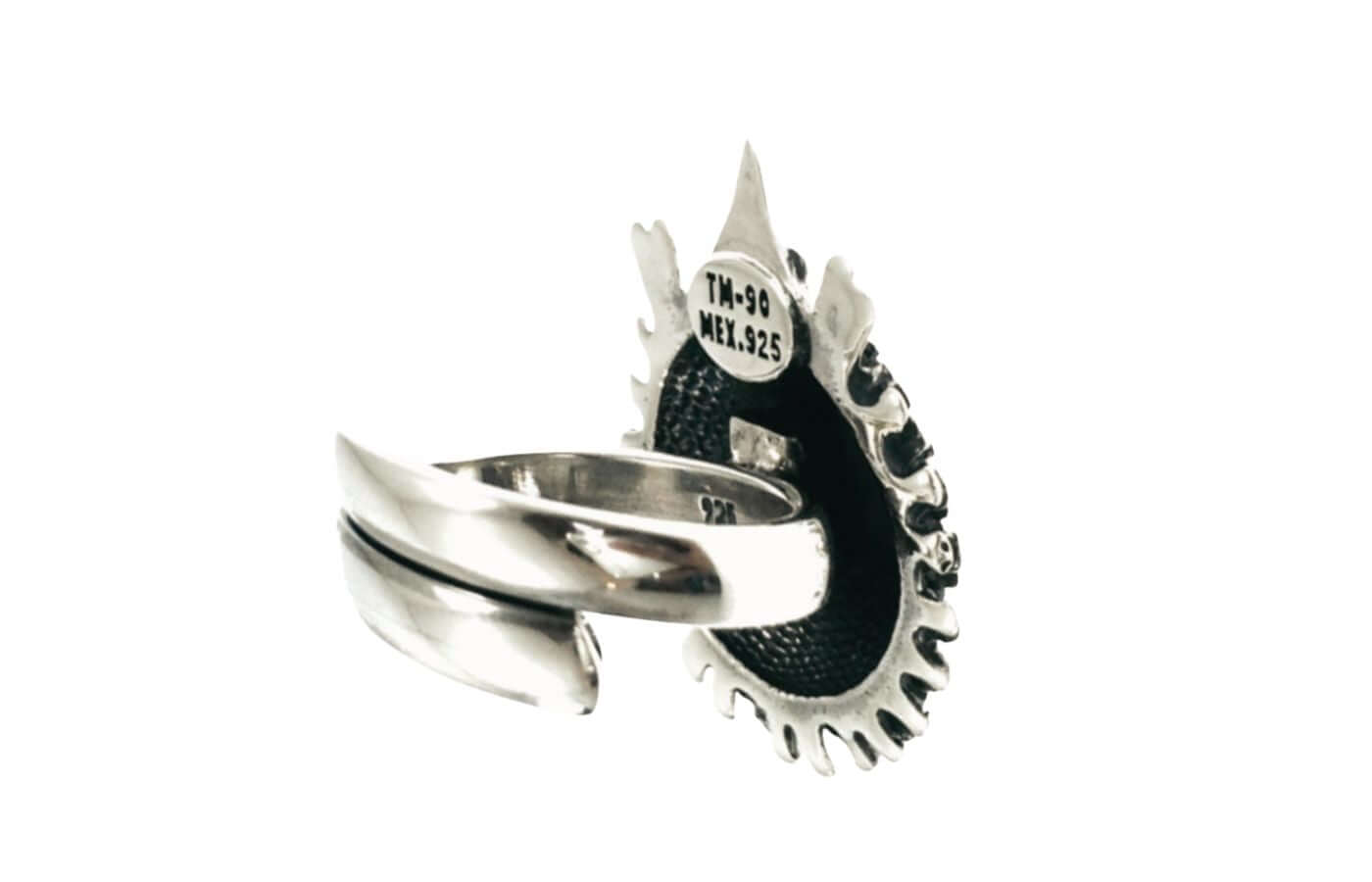 A Taxco sterling silver ring with a textured black inlay and a decorative pointed top, featuring a band with a central split design. The inside of the ring is stamped with 'TM-90 MEX.