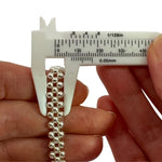A mechanical vernier caliper measuring the precise width of the triple-strand 925 silver beaded bracelet.