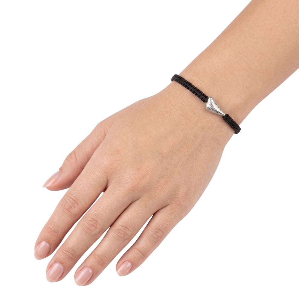 A black braided cord bracelet with a silver triangular charm, shown worn on a person's wrist against a plain white background.