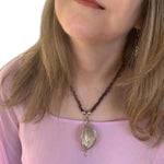 Woman wearing a garnet necklace with a silver pendant