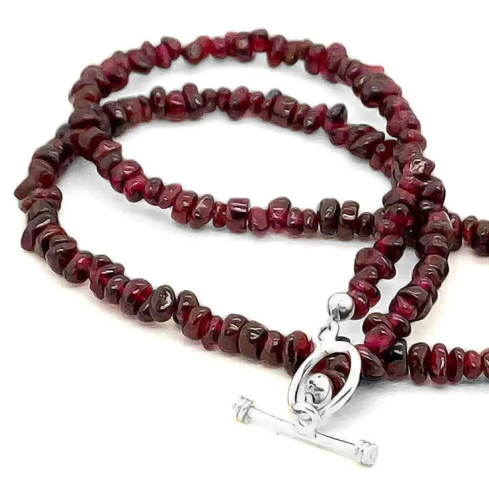 Detail of garnet gemstones necklace with silver toggle bar and ring