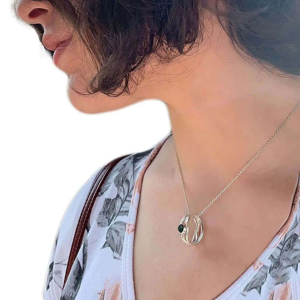 Close-up view of the artisan silver openwork dark pearl pendant worn on an adjustable chain, illustrating its delicate daily scale.